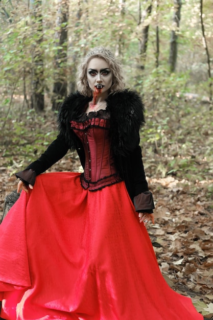 A woman in the image of a vampire or a witch with white makeup and in a medieval dress