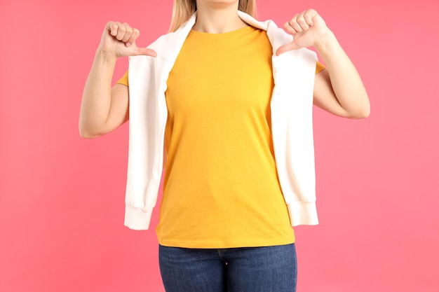 写真 ピンクの背景に空白のオレンジ色のtシャツの女性