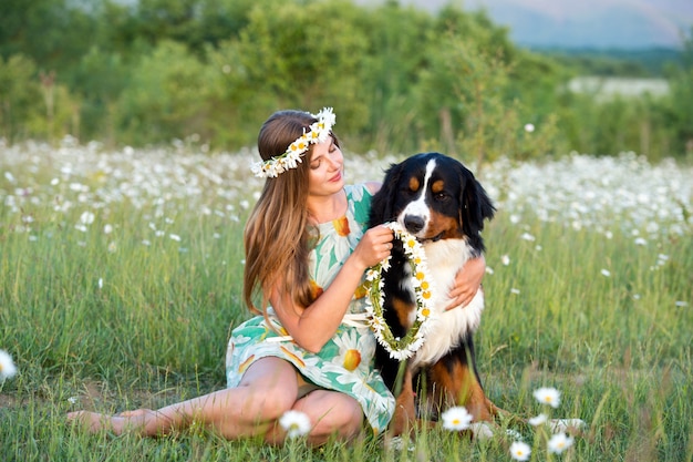 写真 バーニーズマウンテンドッグとカモミールリースの女性。犬を持つ少女