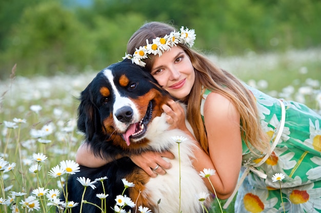 写真 バーニーズマウンテンドッグとカモミールリースの女性。犬を持つ少女