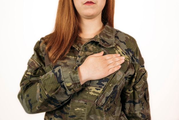 Фото Женщина в военном камуфляже, положив руку на сердце