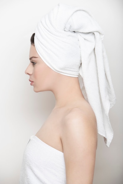 Фото Женщина в профиль в белом полотенце