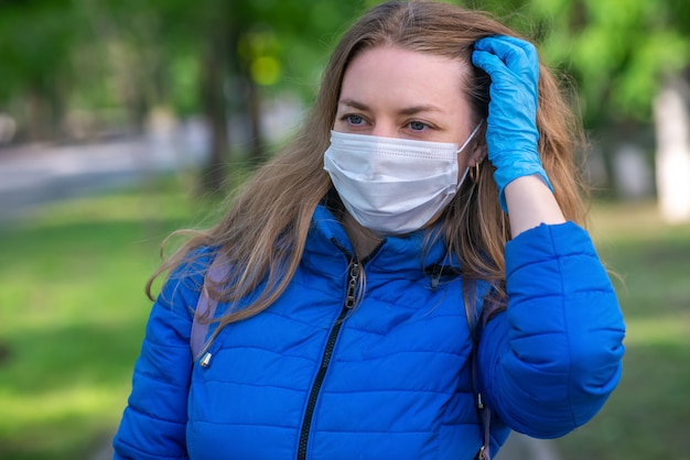 Фото Женщина в защитной маске и перчатках идет по улице