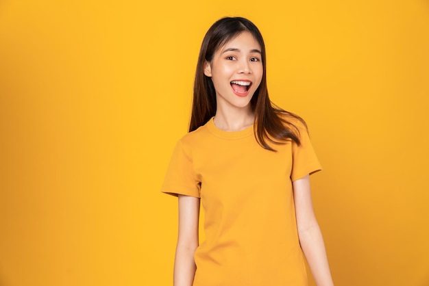 写真 tシャツを着た女性と黄色の背景に立つ