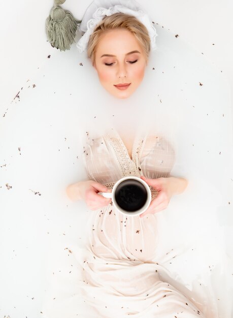 빈티지 옷을 입은 여성이 르네상스 시대처럼 라벤더로 목욕을 하고 커피를 마신다