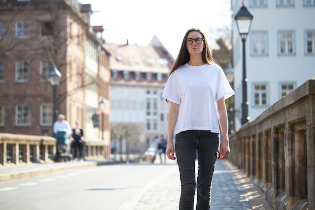 写真 街で眼鏡をかけている白い空白のtシャツの女性