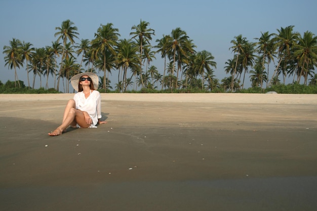 사진 열 대 국가에서 해변에 누워 흰 모자에 여자