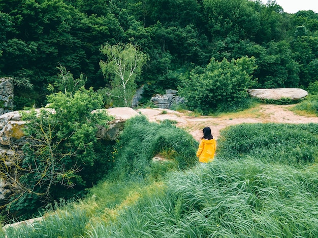 사진 높은 풀 바람이 부는 날씨에 노란 비옷을 입은 여자