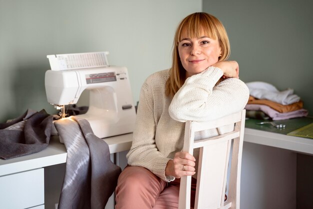 Foto donna che lavora al chiuso con tessuto per vestiti