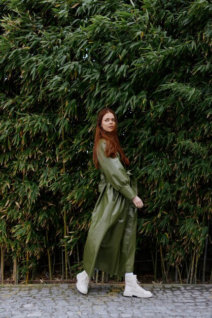 Photo woman influencer in stylish trendy clothes poses fulllength against a backdrop of bamboo trees lifestyle blogger spring