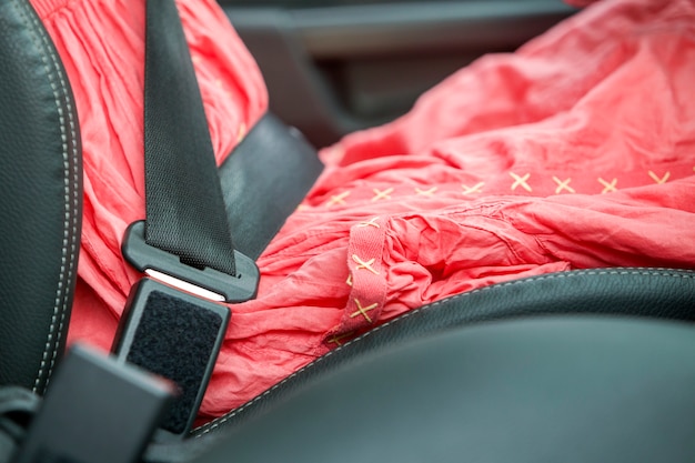 Woman inside car buckled up with protective seat belt.