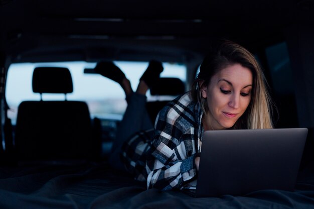 Woman inside van with laptop on road trip vacation  travel having fun watching videos inside van