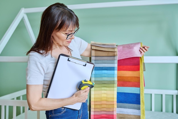 Woman interior designer with fabric tape measure clipboard in client room