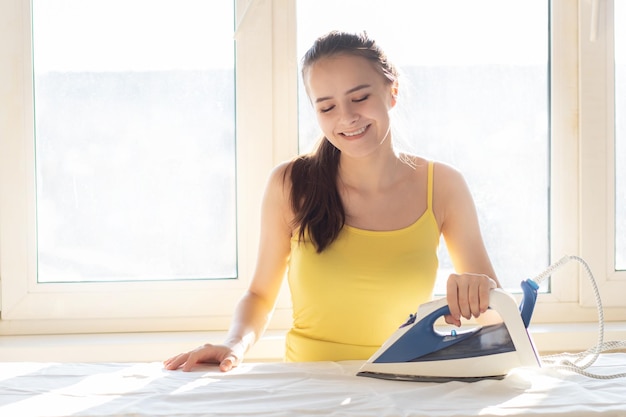 Woman ironing linen at home on the board