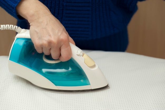 Woman ironing white clothes on ironing board