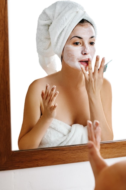 Woman is applying mask on her face