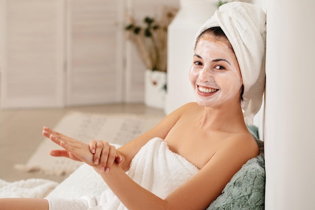 Woman is applying mask on her face