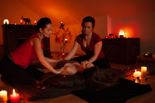 A woman is being massaged by a woman in a red top.
