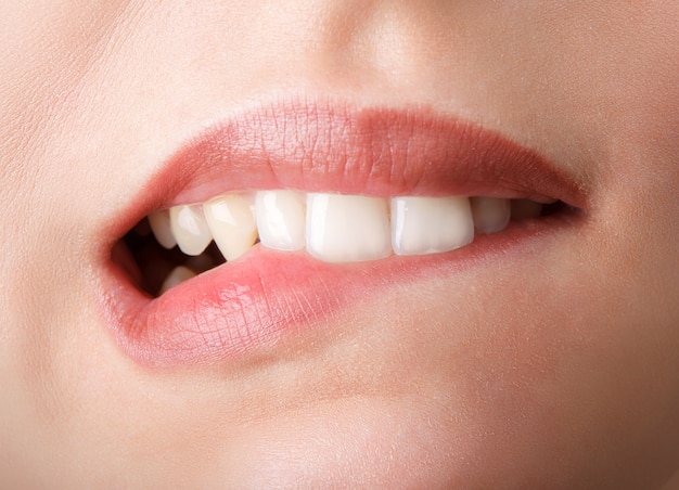 Женщина кусает свои красные губы зубами