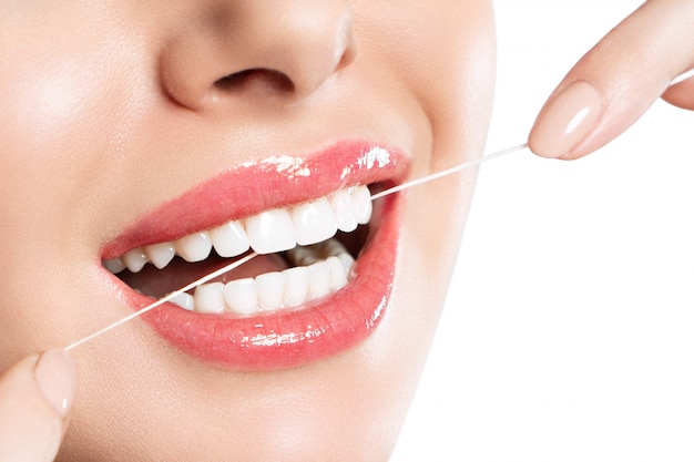 Photo a woman is brushing her teeth using dental floss.