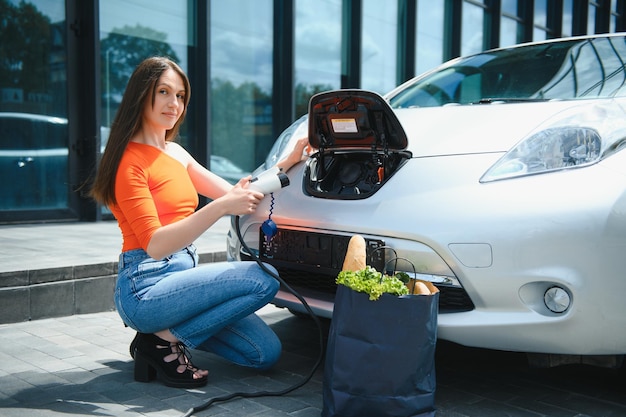 女性が電気自動車のレンタルを充電しています