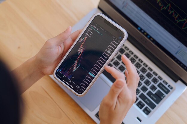 Photo woman is checking bitcoin price chart on digital exchange on smartphone