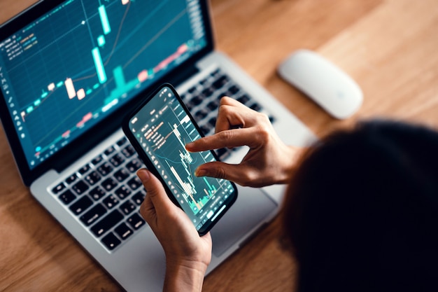 Photo woman is checking bitcoin price chart on digital exchange on smartphone