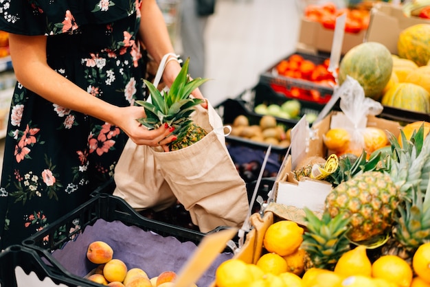 Женщина выбирает фрукты и овощи на продовольственном рынке