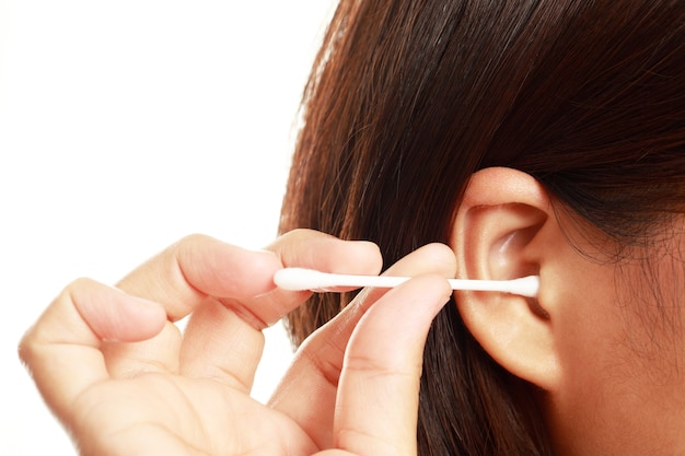 Woman is cleaning ear with a cotton