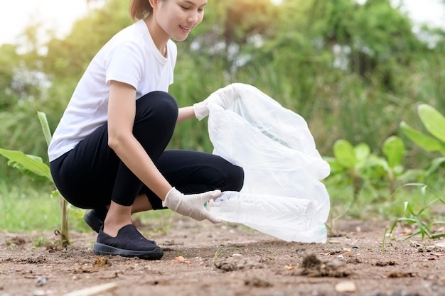 La donna sta raccogliendo spazzatura di riciclaggio sul concetto sostenibile ecologico a terra