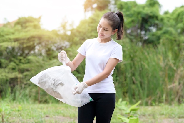 Woman is collecting recycling junk on ground ecological sustainable concept