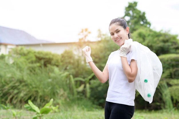 Woman is collecting recycling junk on ground ecological sustainable concept