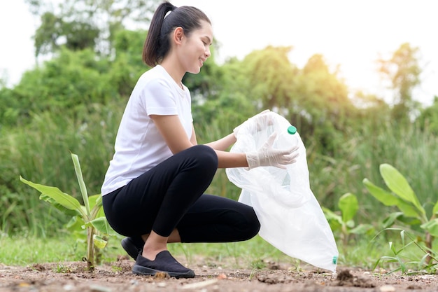 Woman is collecting recycling junk on ground ecological sustainable concept