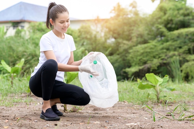 Woman is collecting recycling junk on ground ecological sustainable concept