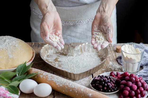 Женщина готовит вкусный вишневый пирог в домашних условиях