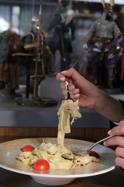 Photo a woman is cooking food with a fork and a knife