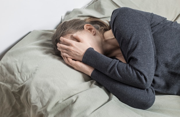 A woman is crying covering her face with her hands. 