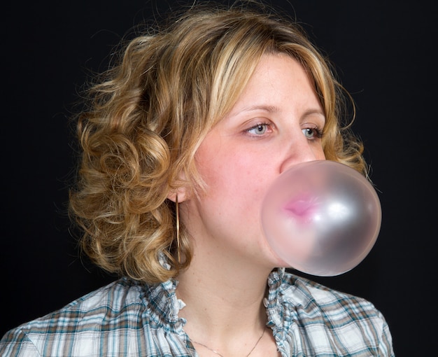 woman is doing bubble  with bubble gum