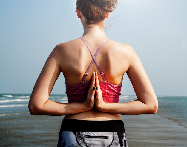 A woman is doing a yoga at the beach