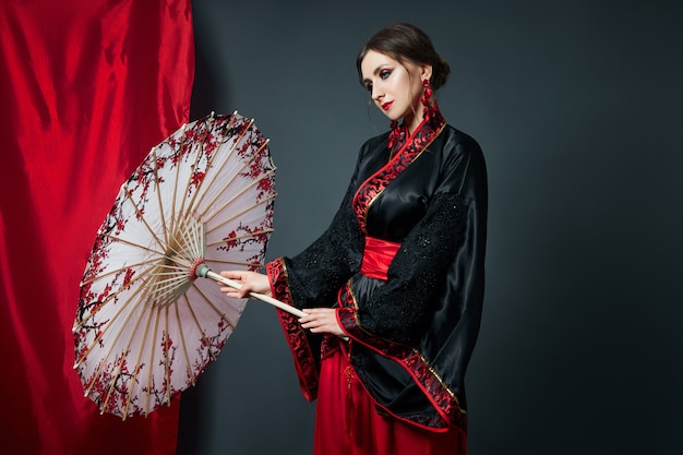 Woman is dressed in red Chinese Japanese folk clothing.