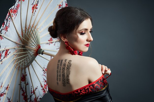 Woman is dressed in red Chinese Japanese folk clothing.