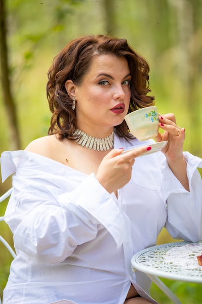 La donna sta bevendo il caffè al mattino sulla natura