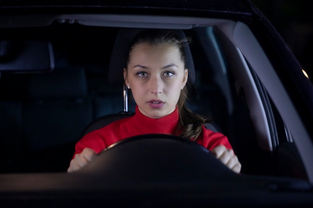 Woman is driving car at night