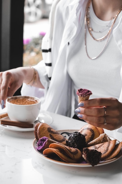 Photo a woman is eating a dessert with a cup of coffee