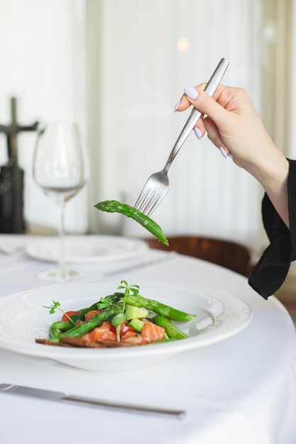 A woman is eating a meal at the restaurant.