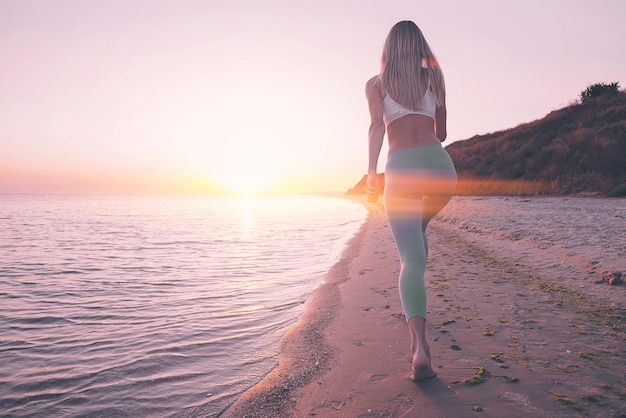 Woman is engaged in sports exercise on the beach