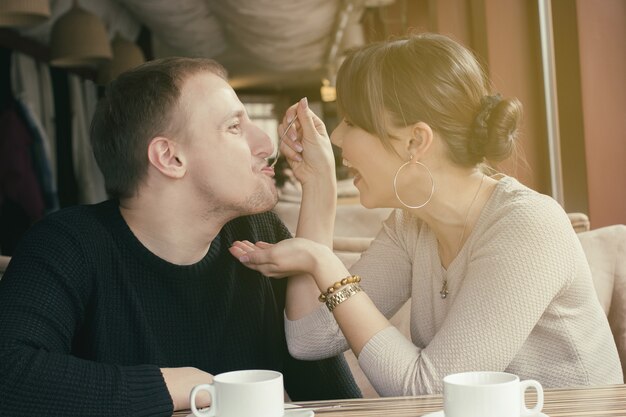 A woman is feeding her boyfriend by dessert and laughing