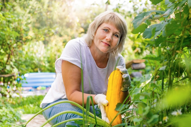한 여성이 집 뒤뜰에서 정원 가꾸기를 하고 있다