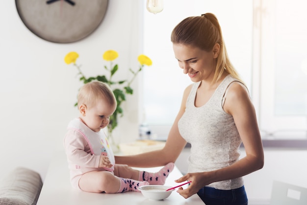 Woman is going to feed the baby with baby food.