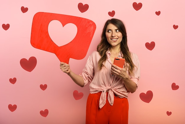 Женщина счастлива, потому что получает сердечки в приложении в социальных сетях
